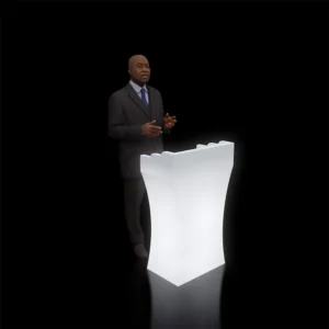 A sleek podium with RGB LED lighting being used by a speaker in a professional setting.