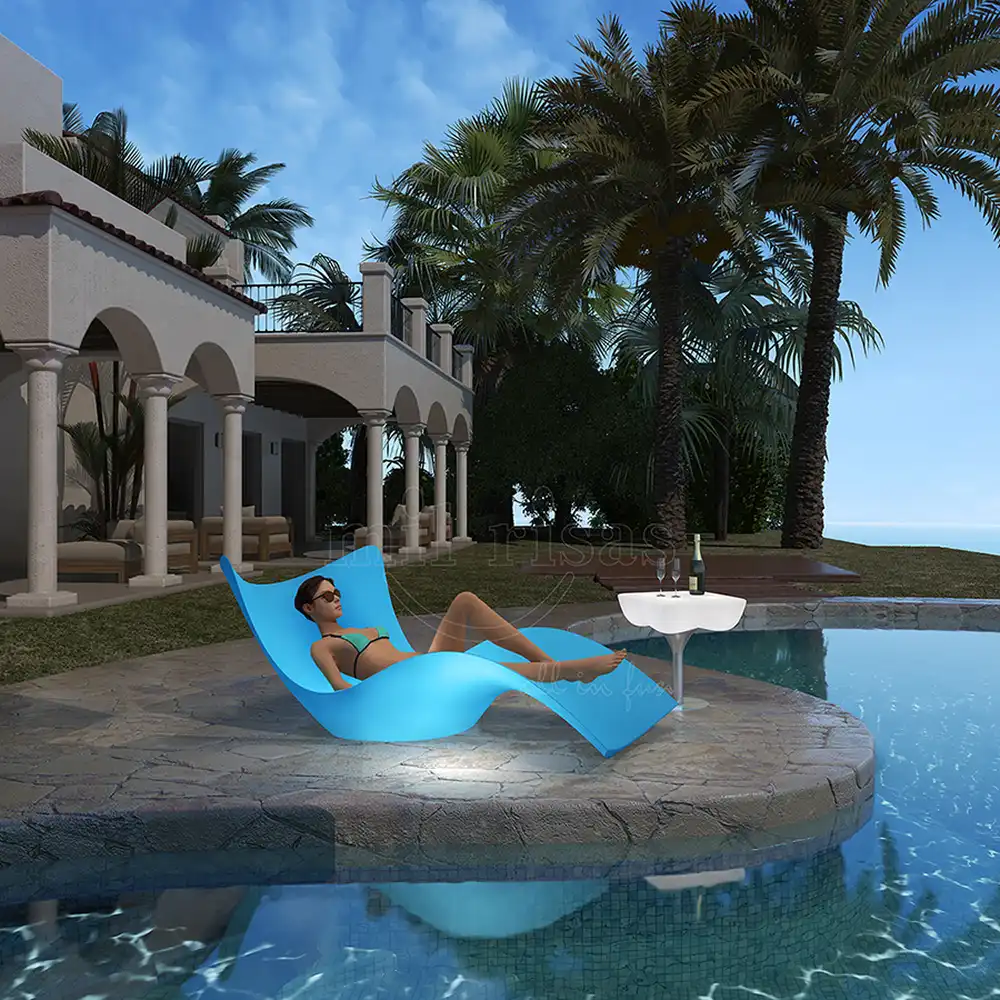 A woman relaxing on a glowing blue led lounge chair by a luxury resort pool, ideal for modern poolside furniture setups.