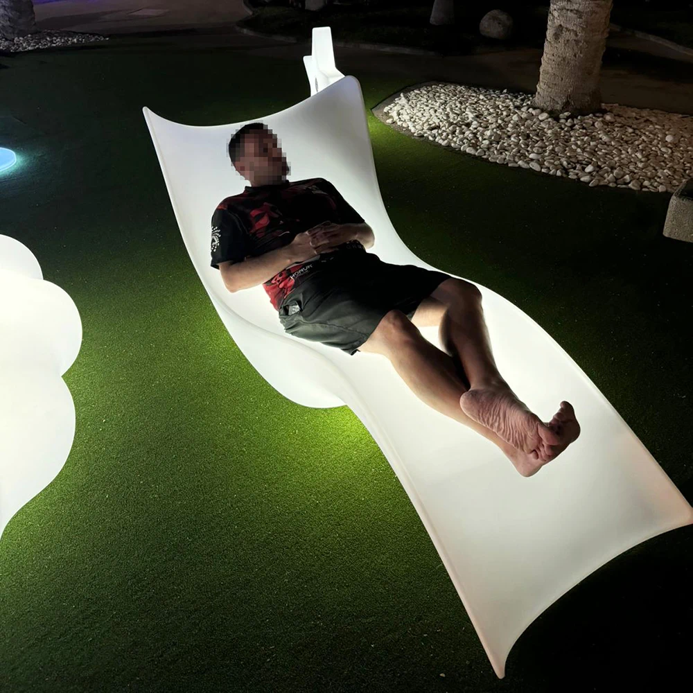 Man Reclining on a Glowing Outdoor Lounge Chair Under the Night Sky