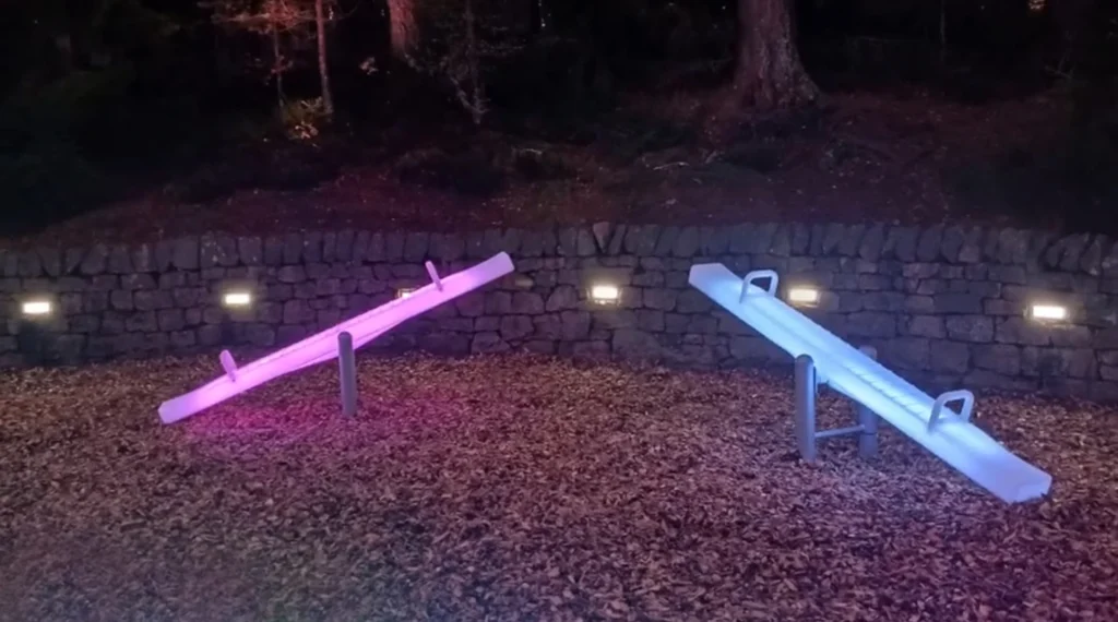 Pink and White LED Seesaws in a Forest, Surrounded by Warm Event Lighting Furniture