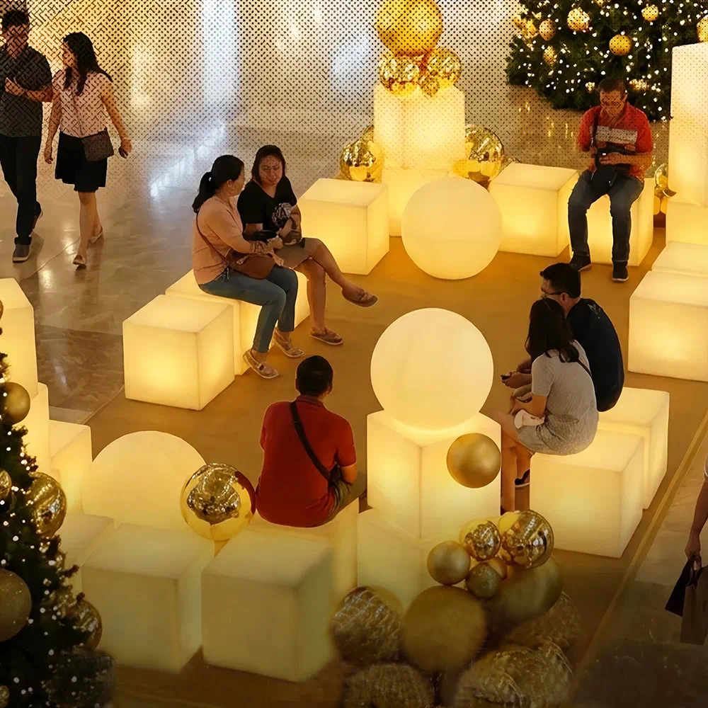 Christmas-Themed Lounge in a Mall with LED Event Decor Furniture, Glowing Cube Stools, LED Balls, and Decorated Christmas Trees