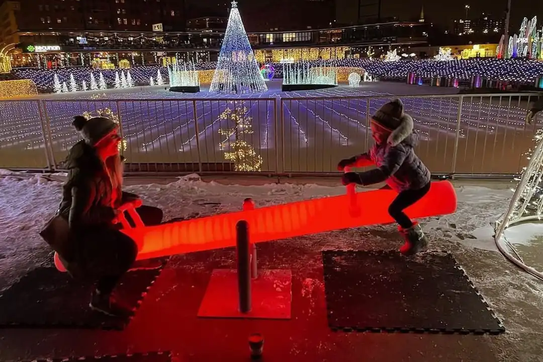 Children playing on interactive LED Glow Furniture seesaws at an outdoor night festival