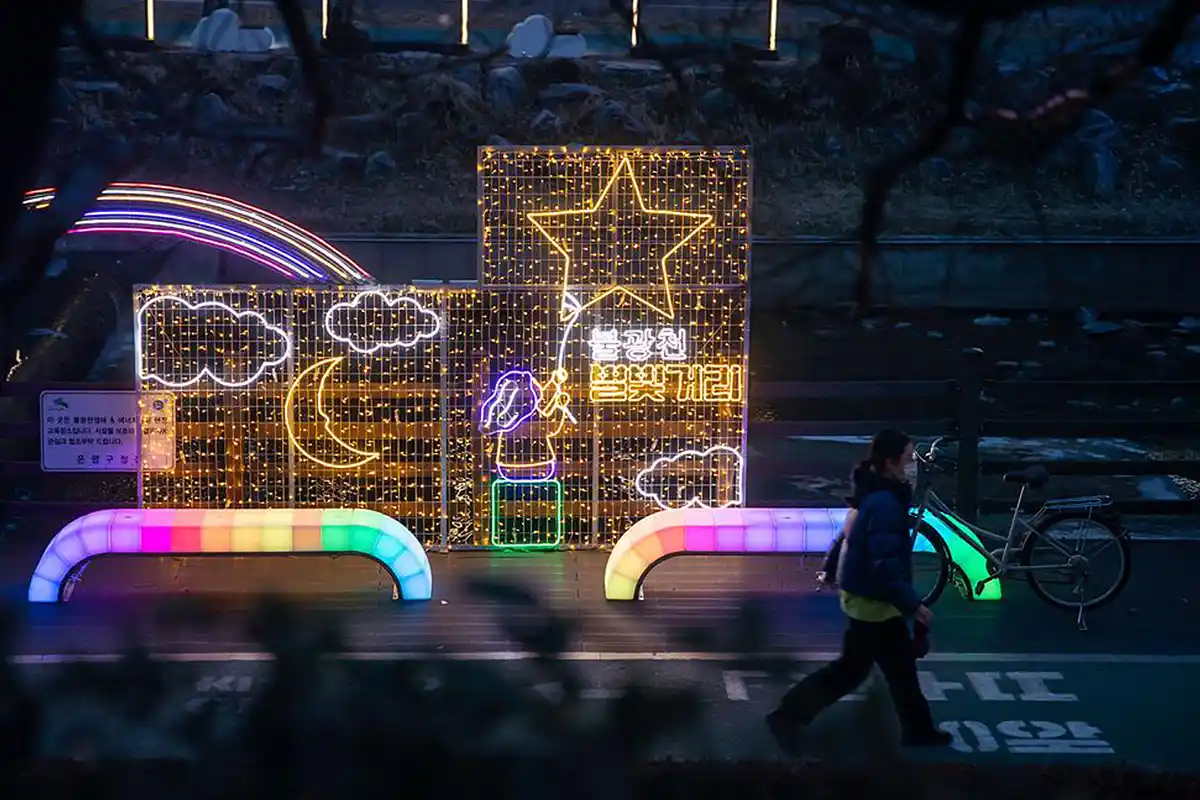 Functional rainbow LED Bench With Light seating installed along a park walkway at night.