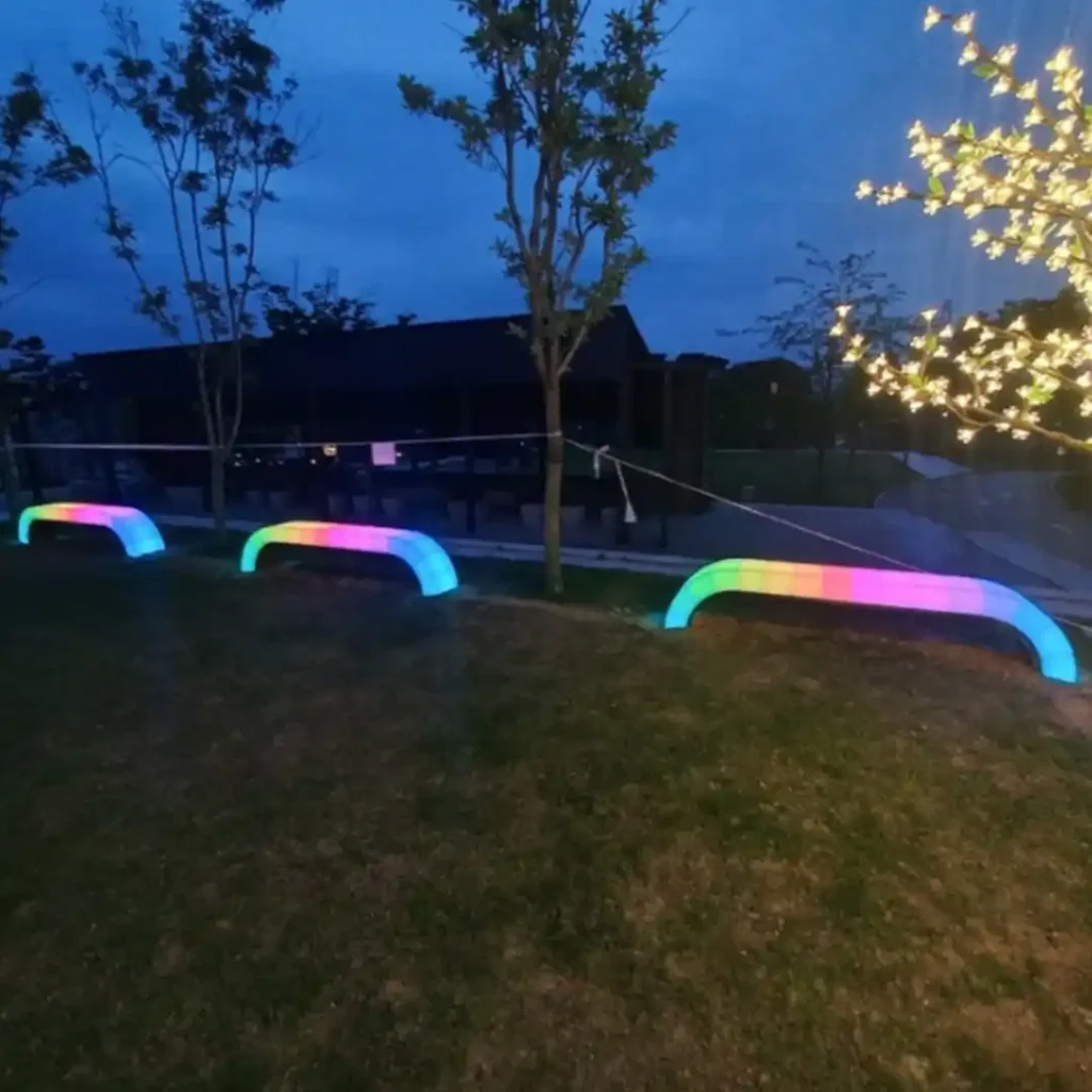 Two glowing arcs of Bench With Light shimmer like rainbows in the nighttime light show.