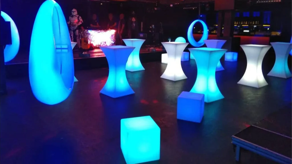 Organisation d'événements à Hengelo, aux Pays-Bas, avec mobilier et éclairage LED comprenant des balançoires LED bleues, des cubes LED et des tables de cocktail lumineuses.