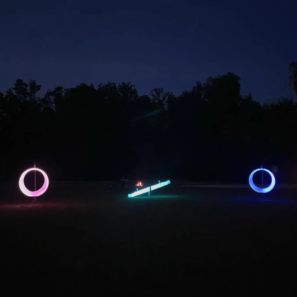 Florida glow furniture RGB-lit LED Seesaw and two LED Swings (PE, weatherproof) at interactive event before trees