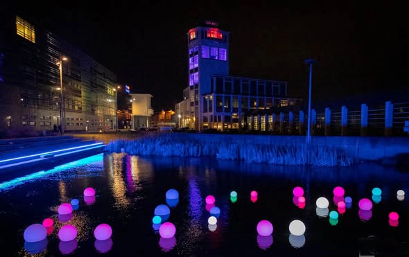 Furniture led lighting installation in Hengelo Netherlands, featuring various sized waterproof LED balls floating on water with multi-color glow at night
