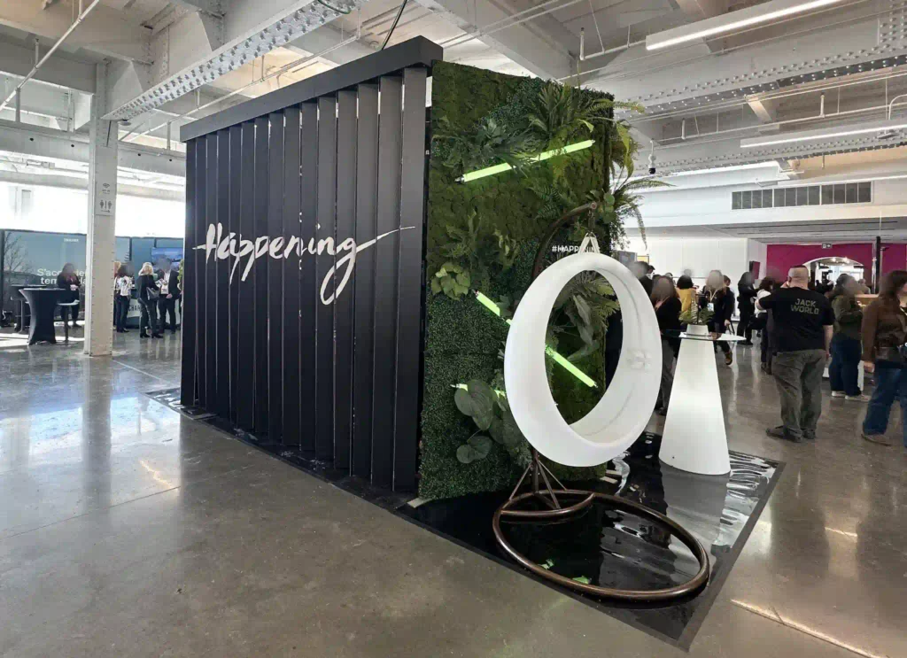 IP65 waterproof LED swing displayed against a green plant backdrop at a Quebec event planning exhibition for illuminated games