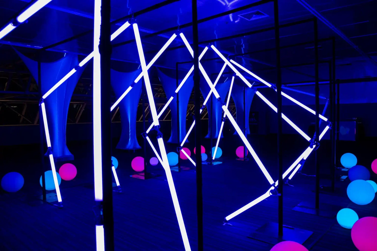 Immersive illuminated games setup in Quebec featuring vibrant multi-colored LEDballs under a blue neon light installation