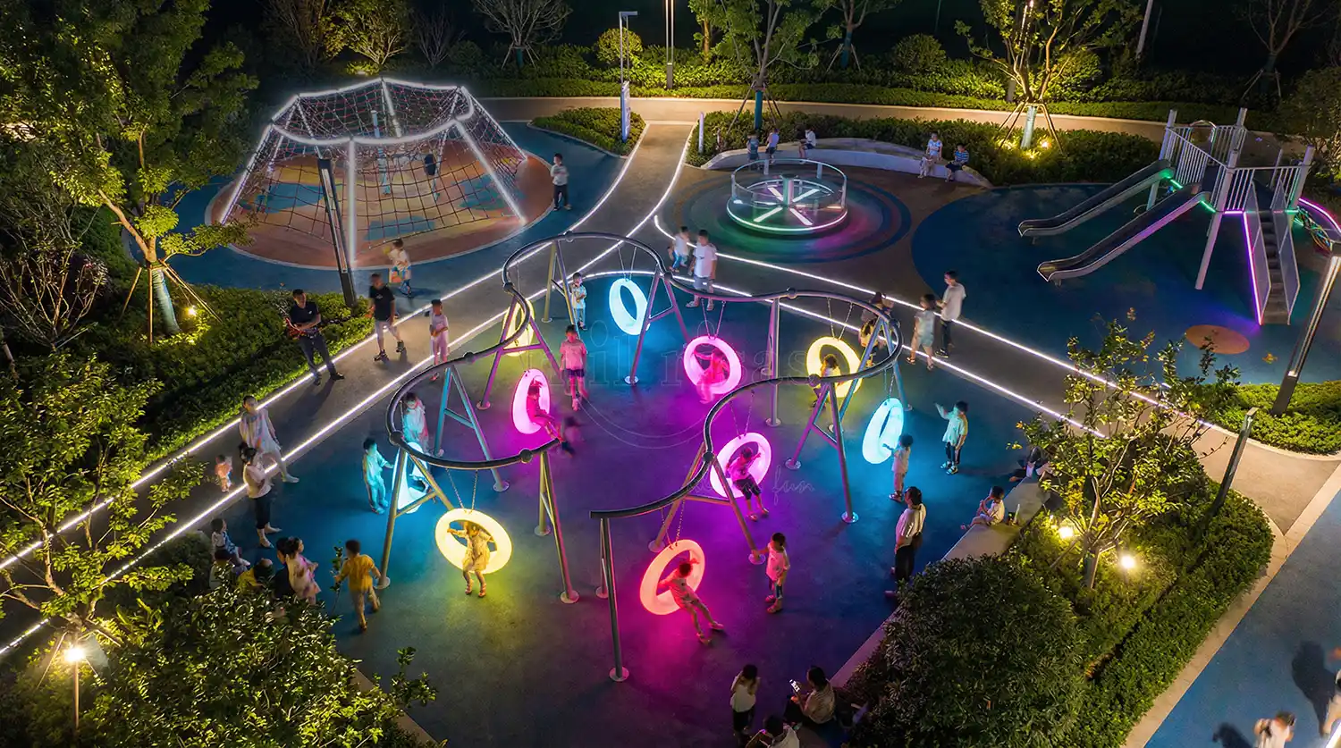 Interactive Kids' Playground Night Landscape featuring a 10-seat LED Round Outdoor Swing System by Milrisas.