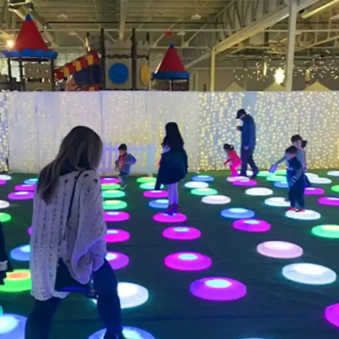 Mobilier interactif à LED lumineux avec dalles de sol rondes illuminées pour une aire de jeux intérieure pour enfants