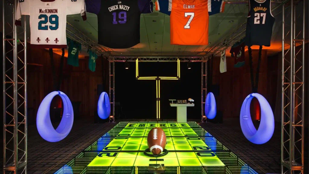 Balançoire interactive lumineuse émettant une lumière violette de part et d'autre d'un sol LED jaune lors d'un événement sur le thème du sport au Colorado, aux États-Unis