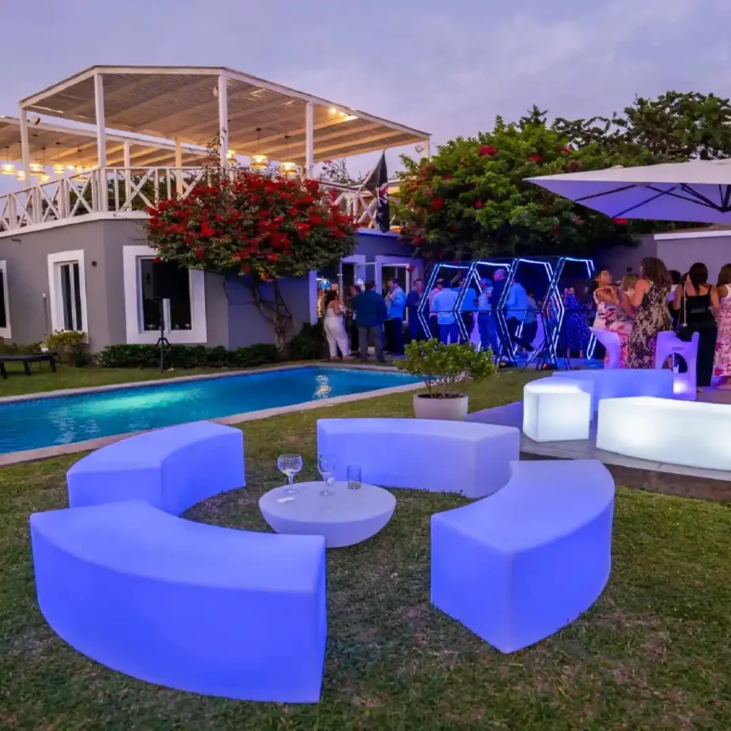 Luxury poolside setting featuring curved LED glow party furniture and illuminated coffee tables for an elegant nighttime event.