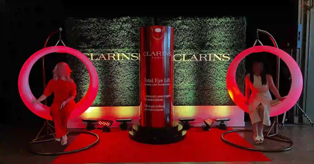 Two LED swings with flexible RGB systems at a Quebec brand event, featuring guests and a Clarins display for illuminated games