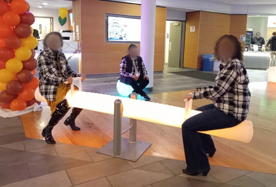 Two cheerful guests playing on the illuminated LED seesaw, a type of lighted games product, at a New York event