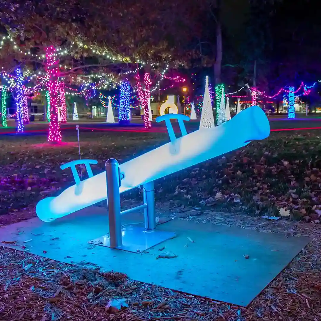 Balançoire illuminée vert brillant faisant partie de la collection de balançoires circulaires à LED, créant une expérience de jeu magique pour les enfants lors d'un événement lumineux de Noël